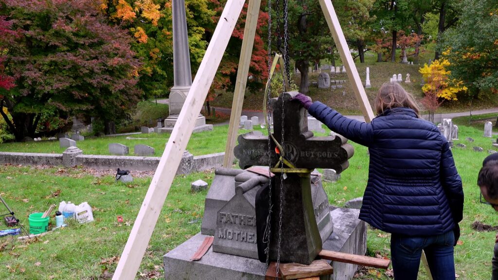 Granite cross suspended in straps under the tripod