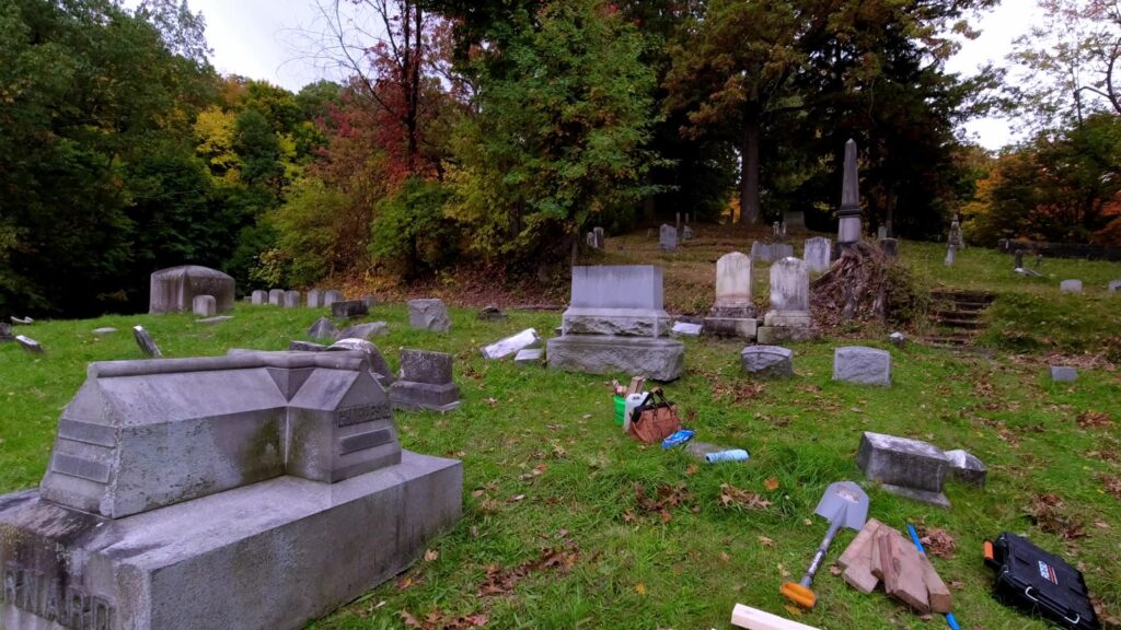 Sections of the granite Barnard monument lying in cemetery grass