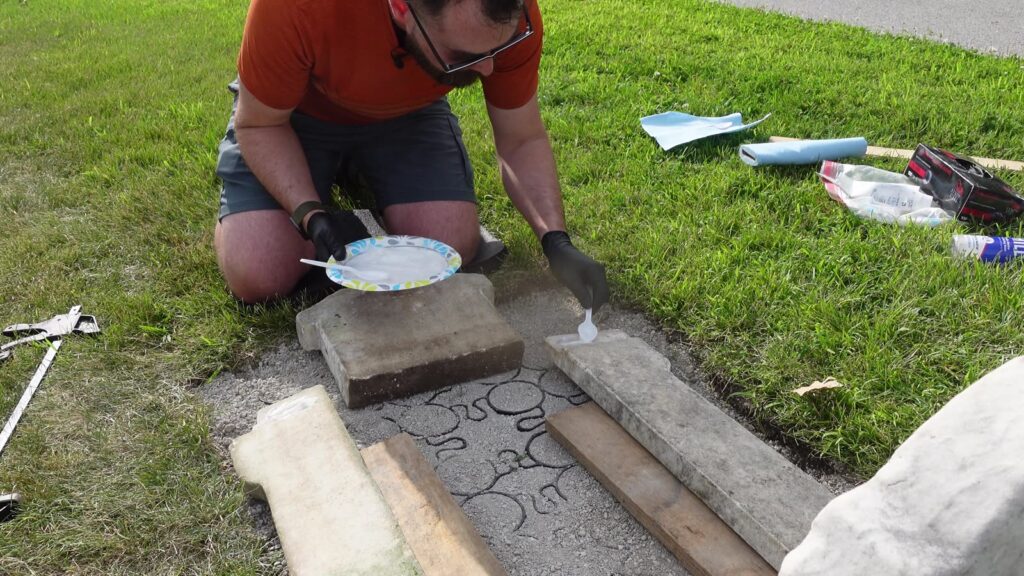 Wade applying knife-grade stone epoxy to a monument rail