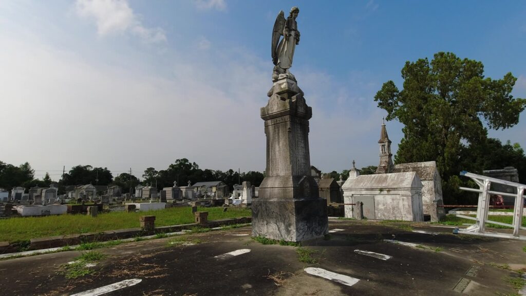 The Fire Angel monument dark with biological growth before cleaning