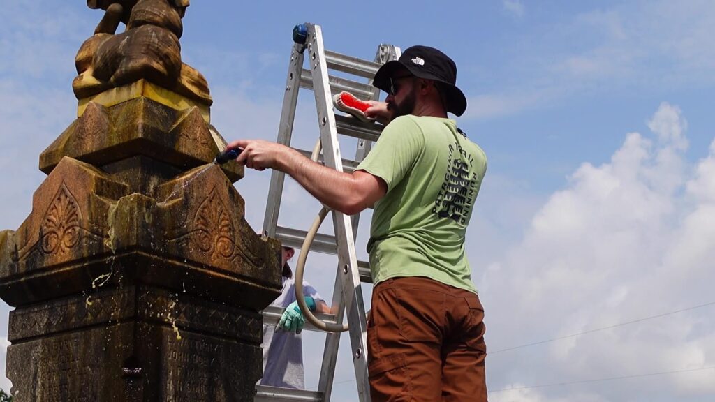 Scrubbing the carved capital of the monument