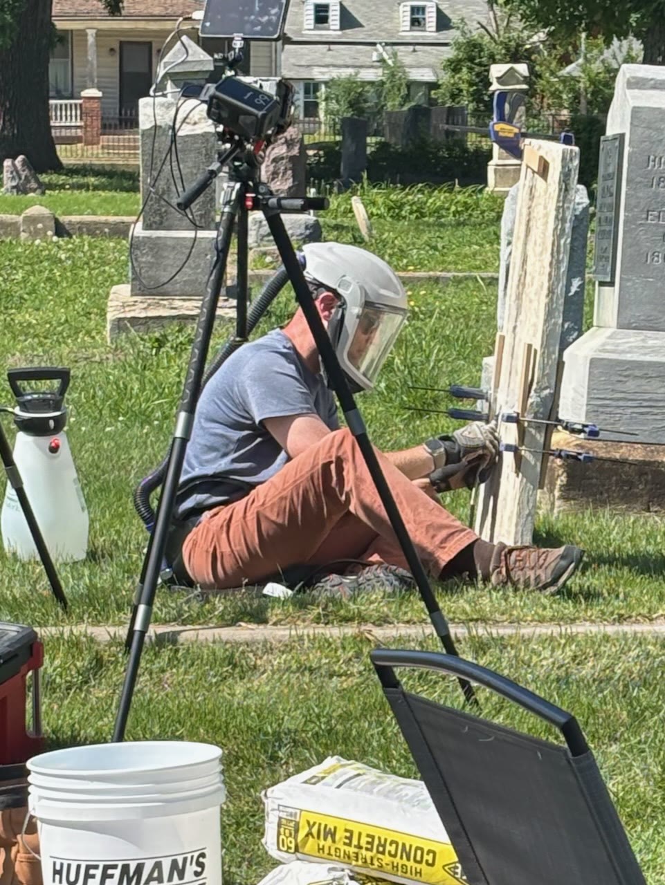 Working slowly with a rotary tool inside the joint to remove the old repair material and separate the pieces. Clamps and battens supported the stone.