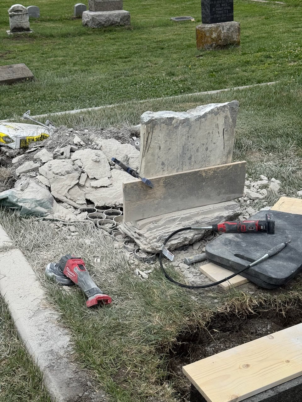 Removing the failed base. The tablet had been wet set into Portland cement after the original limestone keyway failed.
