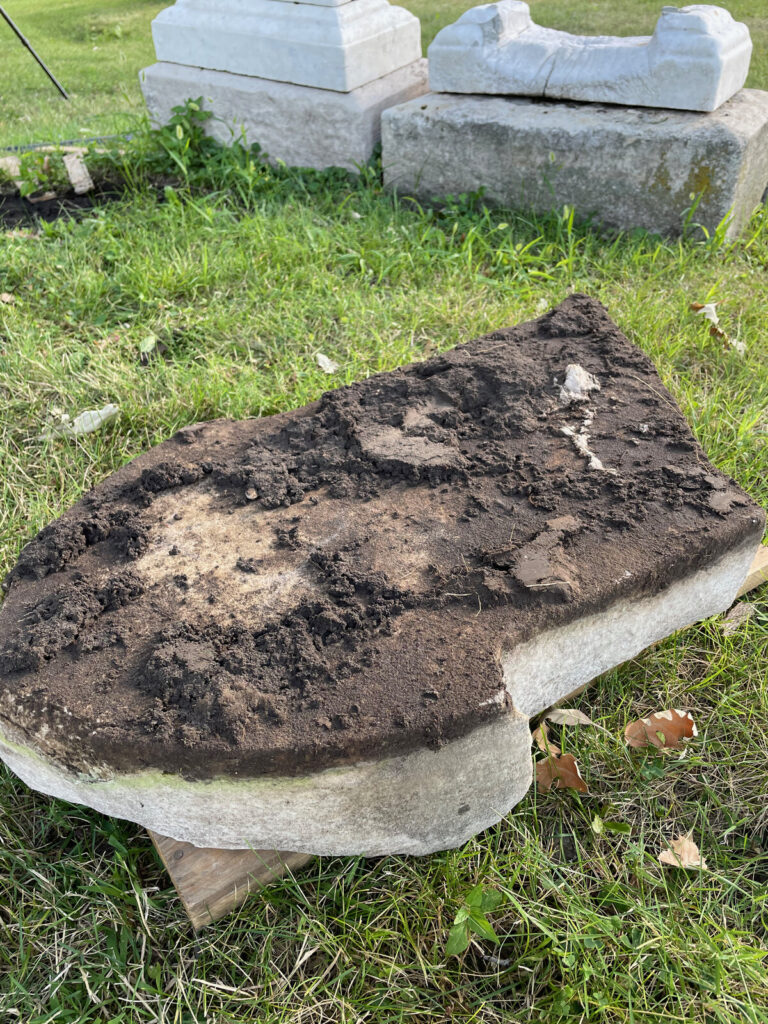 Excavated marble slab covered in soil