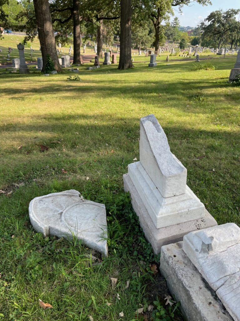 Fallen broken marble monument lying in the grass