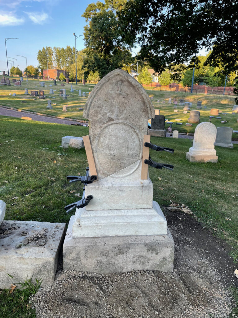 Monument reset upright on its base with clamps